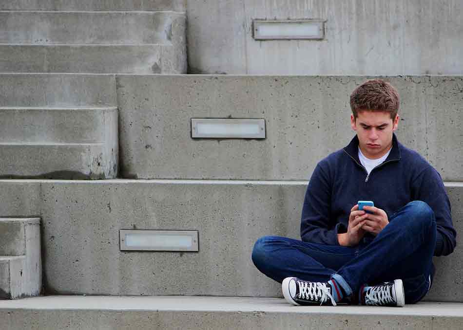 Lenguaje de los adolescentes. Conocer mejor cómo se expresan los adolescentes, Adolescente consulta su celular-móvil