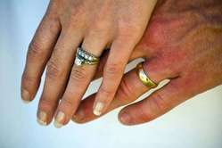 Manos de los novios. Manos con las alianzas de casado y anillo de compromiso.