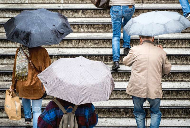 Paraguas. Personas con sus paraguas subiendo unas escaleras.