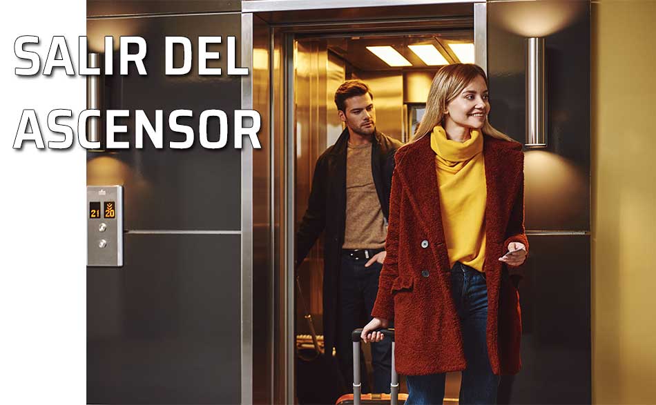 Salir del ascensor. Una mujer sale del ascensor con su maleta