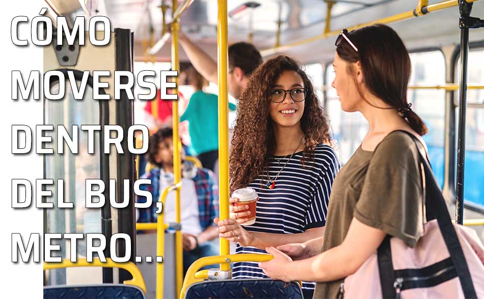 Moverse en un autobus o metro. Dos mujeres charlan dentro de un autobús