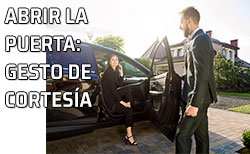 Cortesía y automóvil - coche Un hombre abre la puerta del automóvil a una mujer