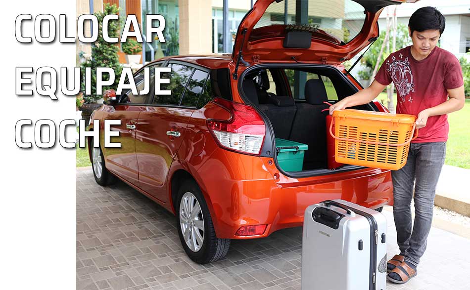 Colocar equipaje coche. Un hombre coloca su equipaje en el maletero del auto