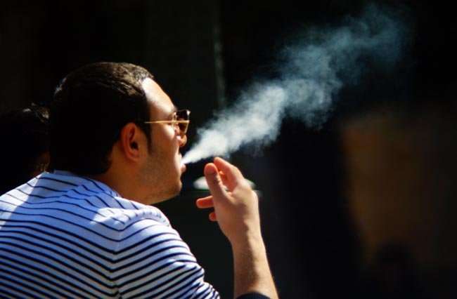 Fumar. Hombre fumando. Estado de espera, meditando, reflexionando. Pensar en algo